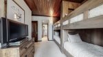 Second bedroom offers two bunks, balcony access, ski locker and en suite bathroom